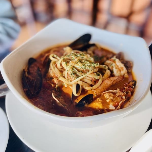 Cajun seafood pasta with mussels, shrimp, and crab in a rich red sauce, topped with parsley.